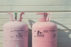 2 pink propane bottles against a white building