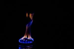 flame from a propane stove burner against an all black background