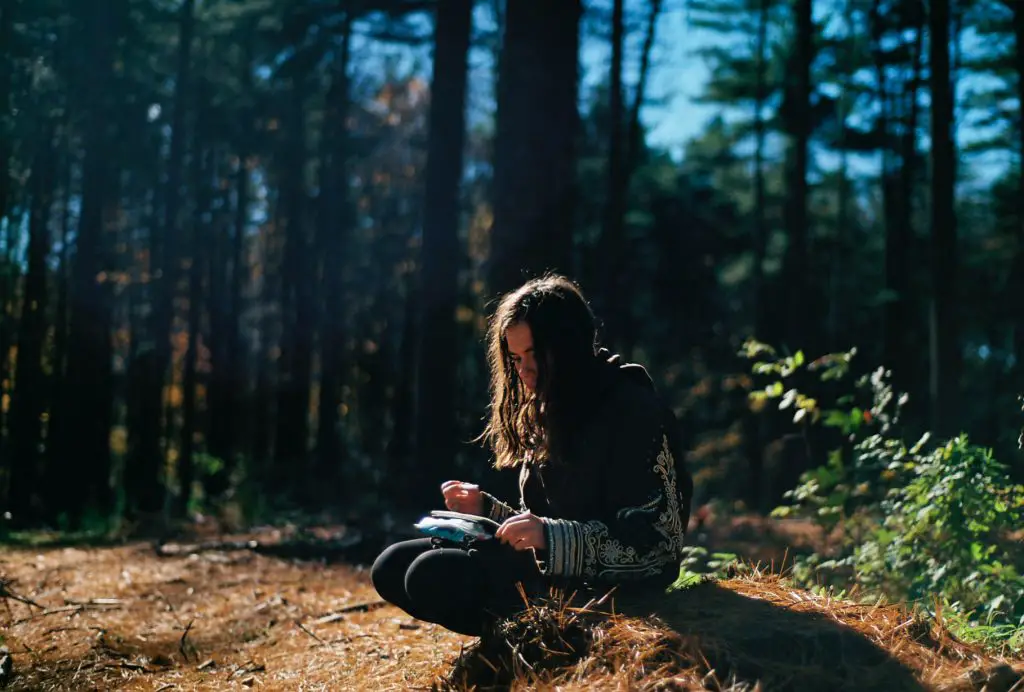 Girl writing in woods