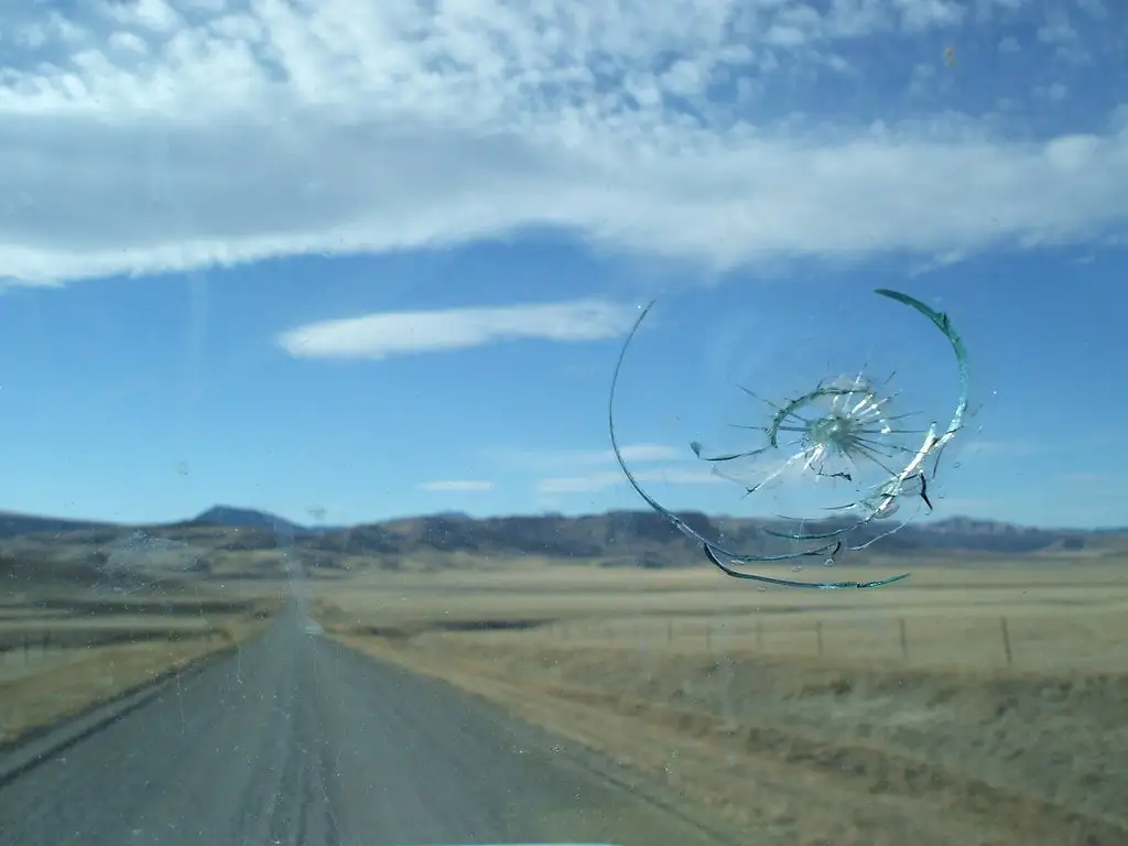 View of a windshield to the outside with a large crater crack