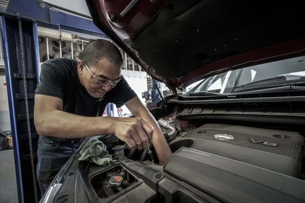 Man working on the engine of a vehicle