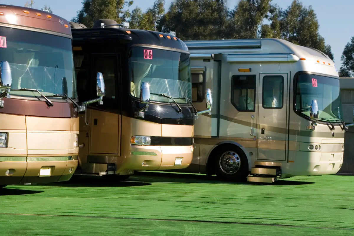 3 Class A motorhomes parked on green turf