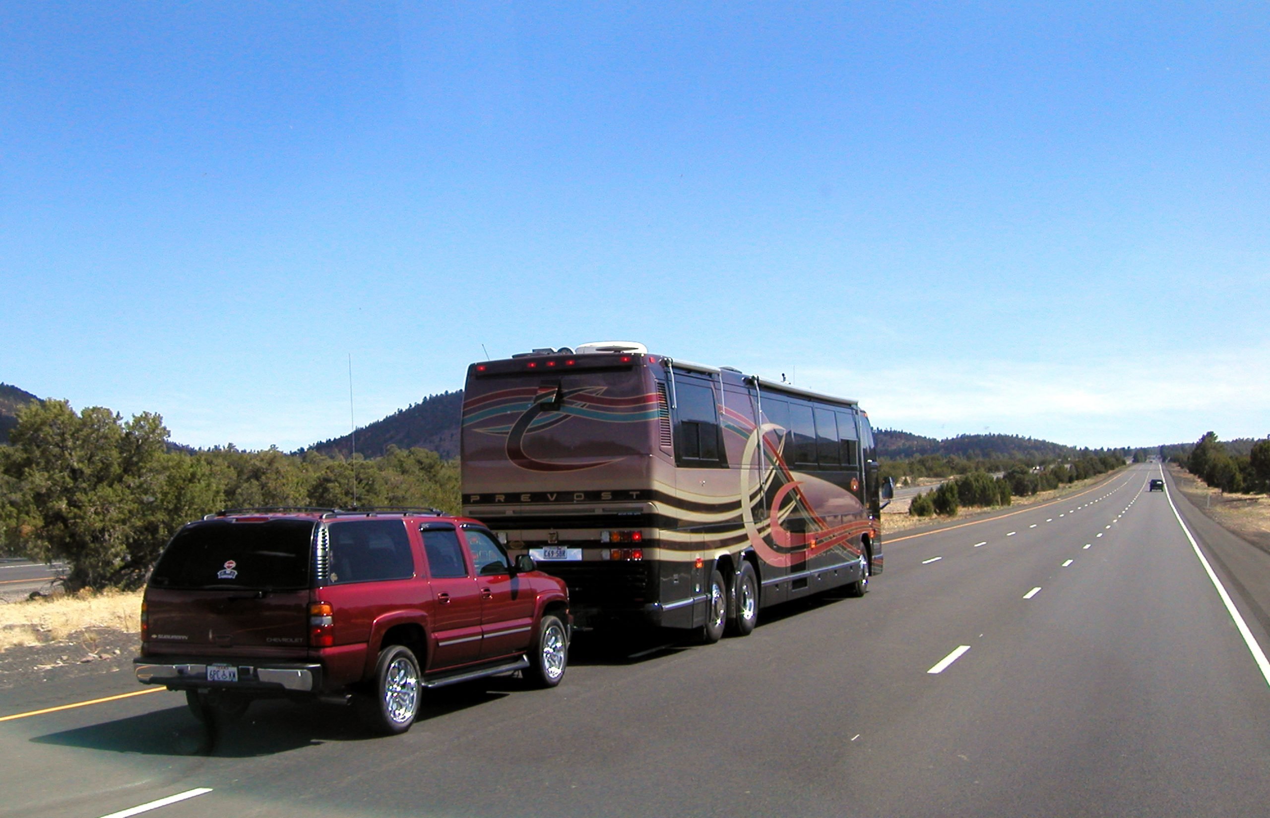 Class A motorhome towing SUV down mountain road