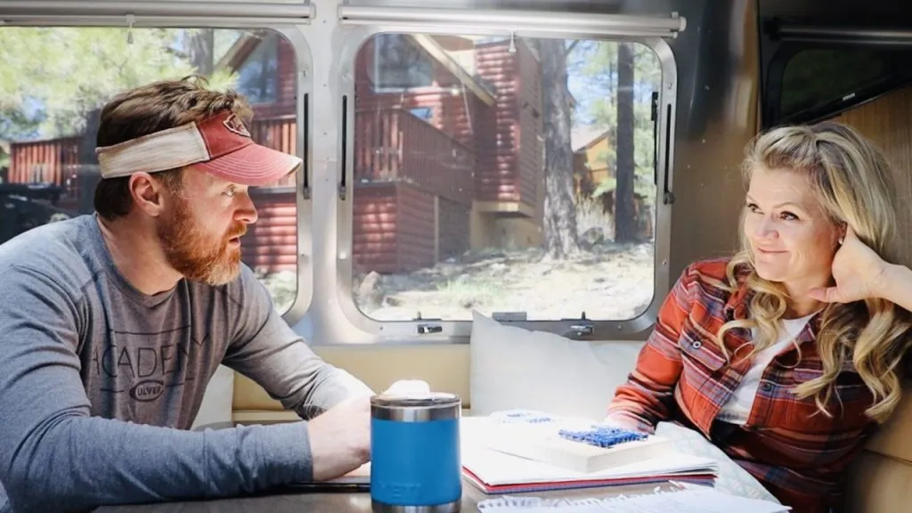 Podcast hosts sitting at a table in their RV talking