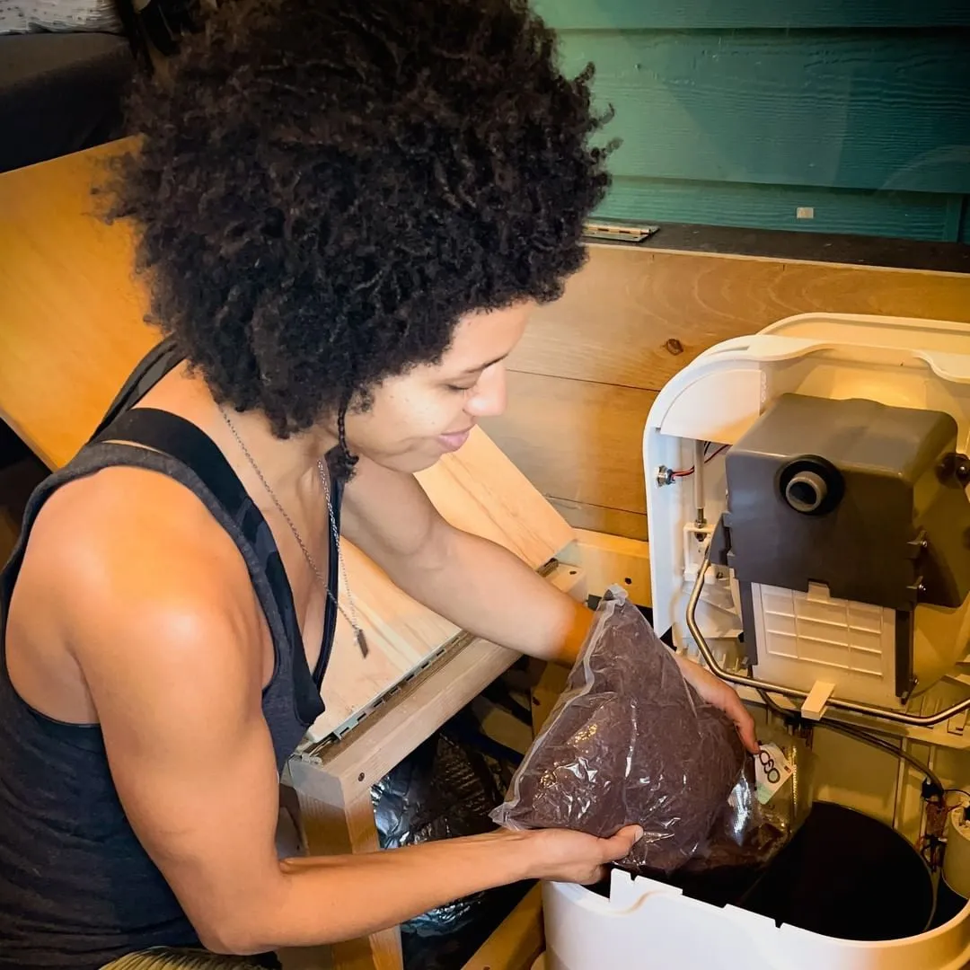 Woman adding coco coir to composting toilet